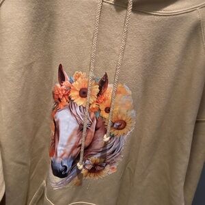 A beige hoodie with a horse